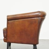 Neat, elegantly finished, cozy sheepskin club armchair with a fixed seat cushion