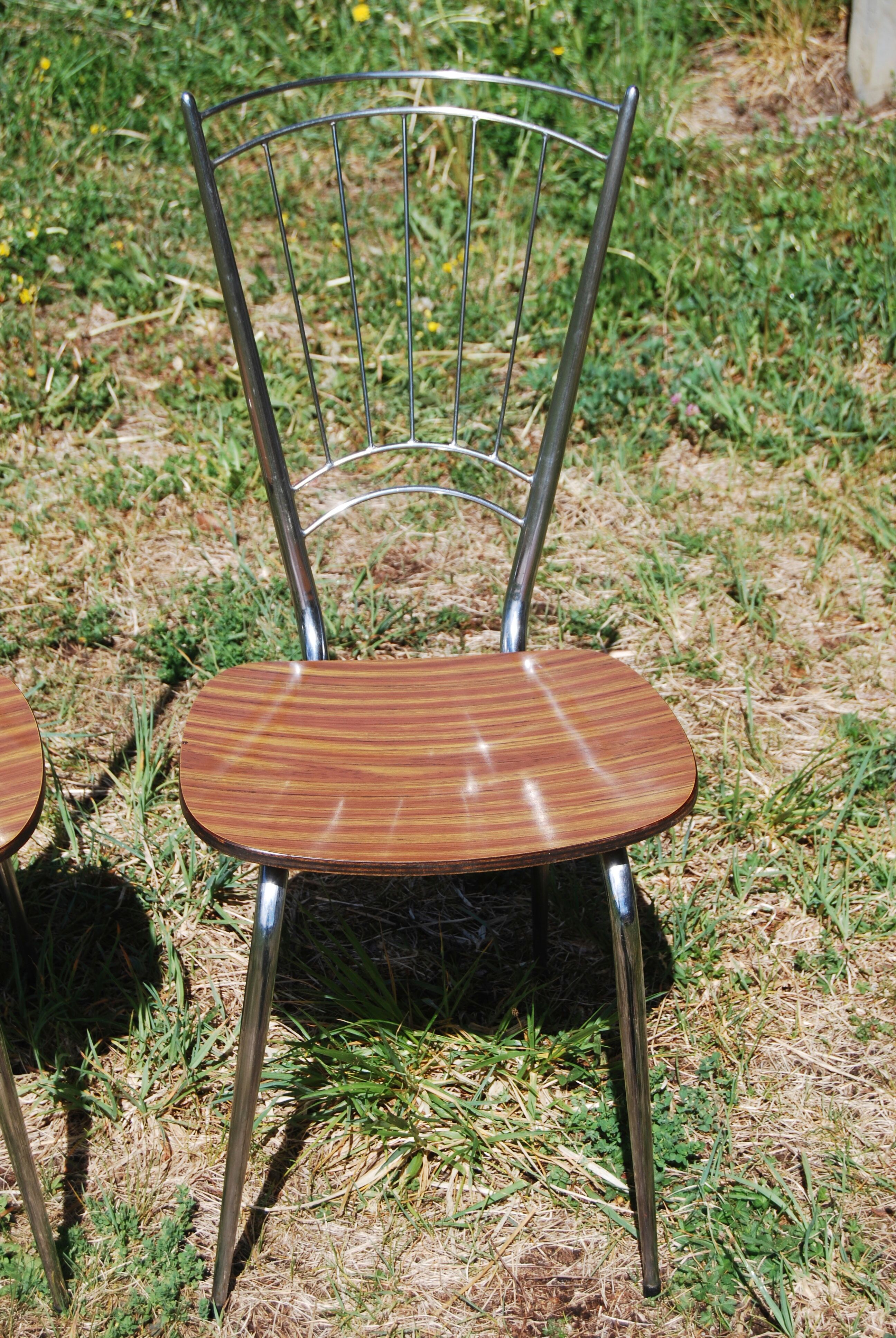 Pair of formica chairs with chrome metal backs in the shape of a lyre.