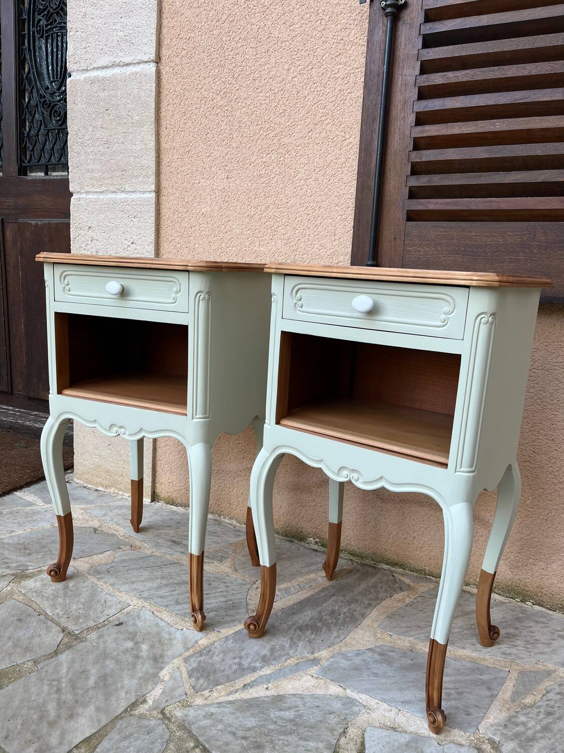Renovated bedside tables in laurel green and light wood.