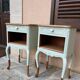 Renovated bedside tables in laurel green and light wood.