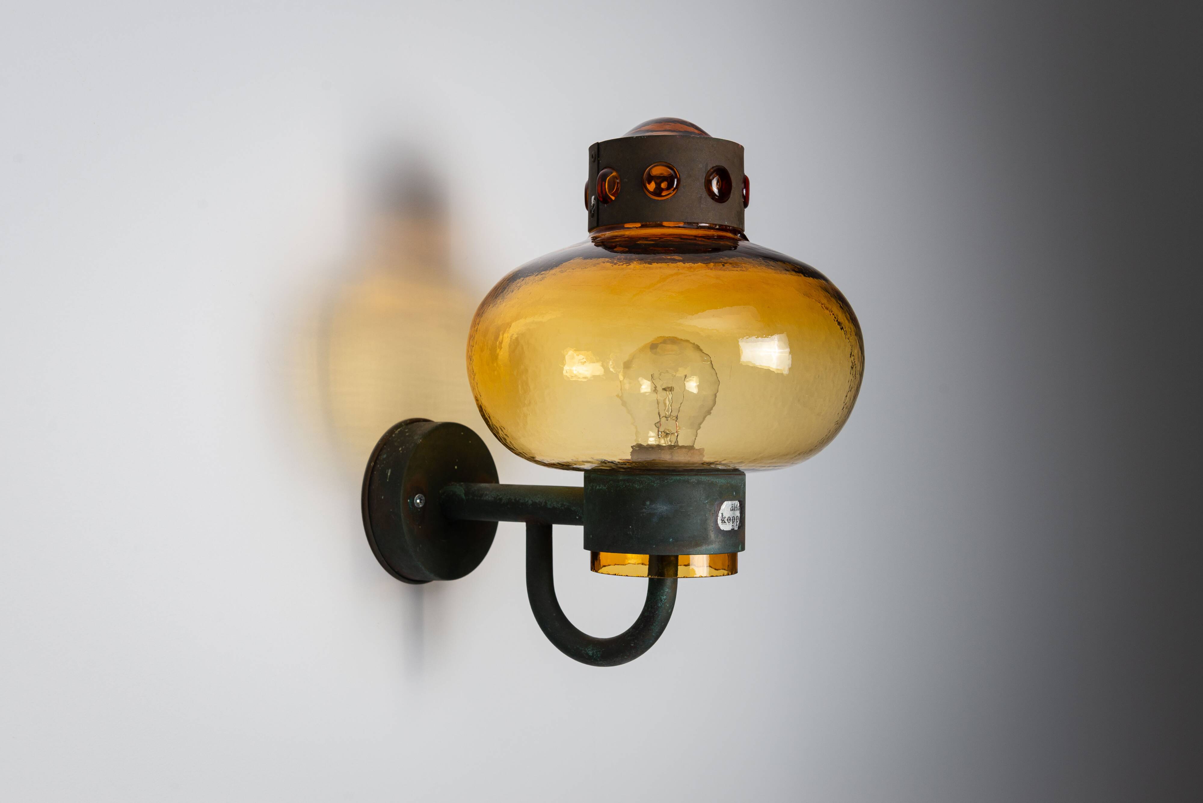 Pair of brass wall lamps with decorated amber coloured shades