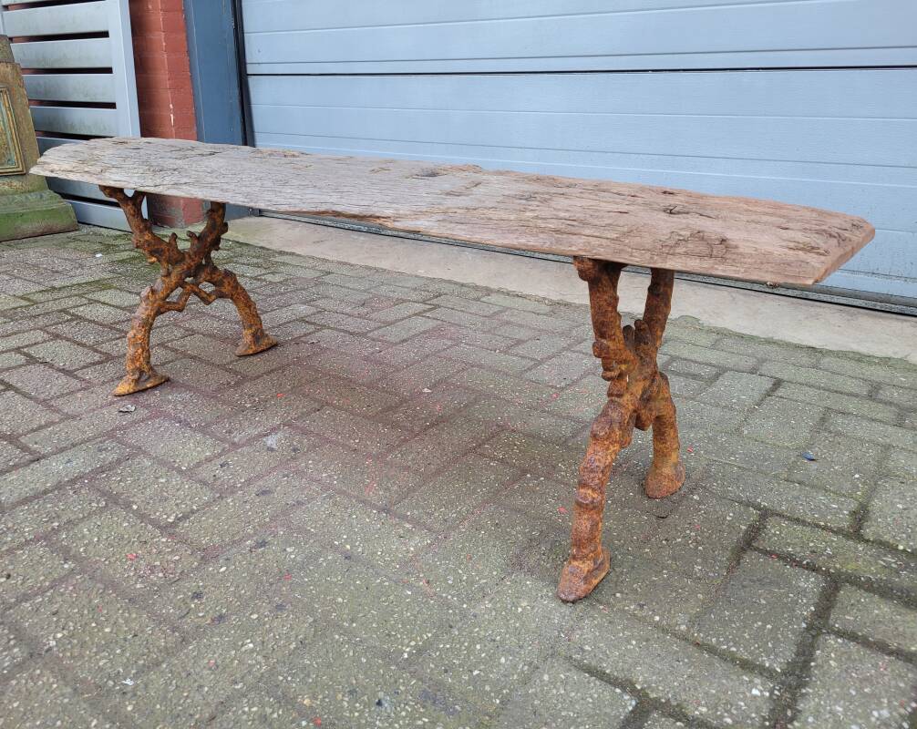 French country style cast iron bench with old rustic wooden plank