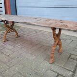 French country style cast iron bench with old rustic wooden plank