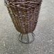 Vintage umbrella stand in rattan, woven wicker, and steel.
