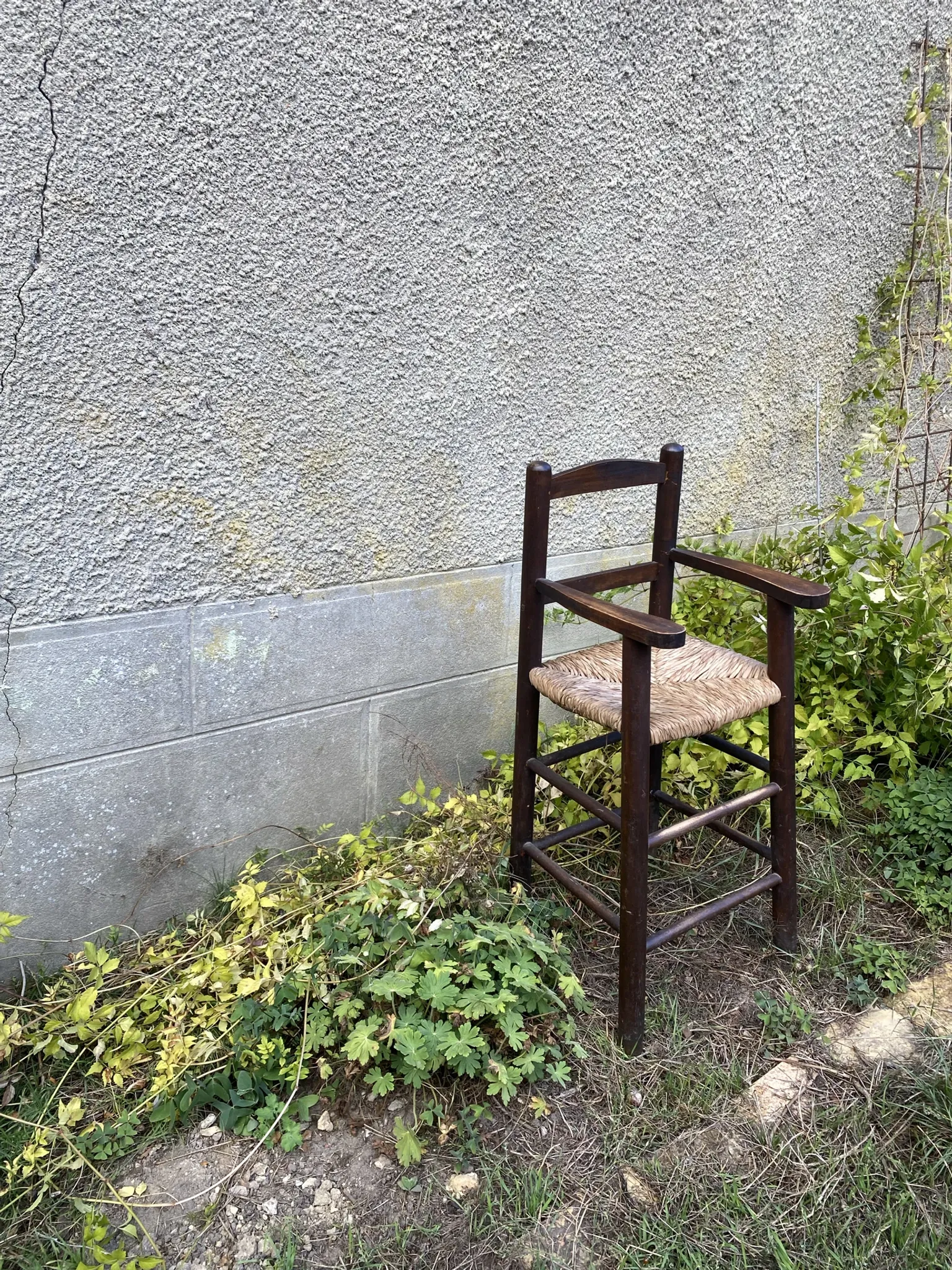 Vintage wooden children's high chair with straw.