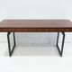 Wooden desk with drawers and black lacquered legs.