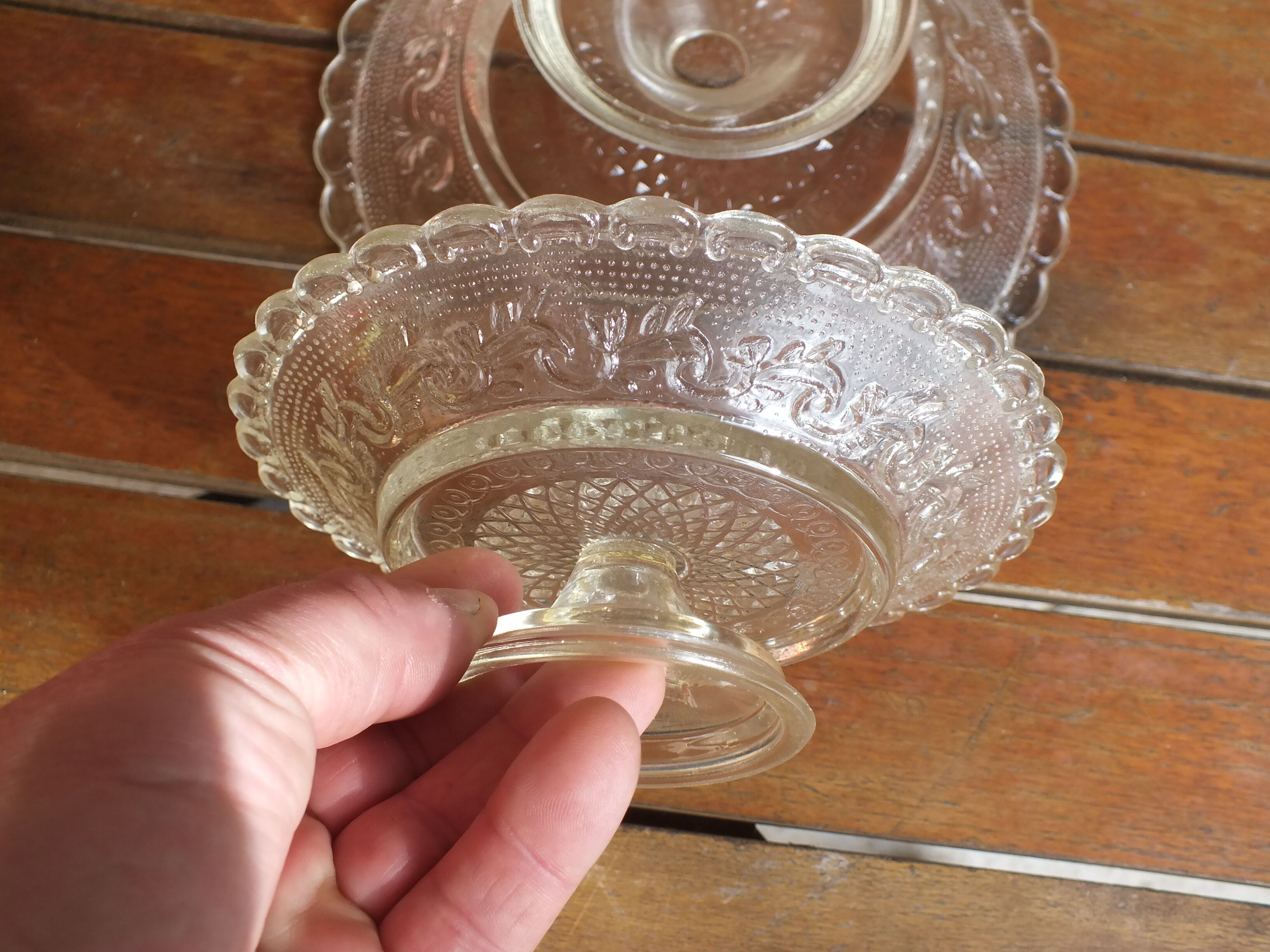 Duo of molded glass display cups, arabesque décor