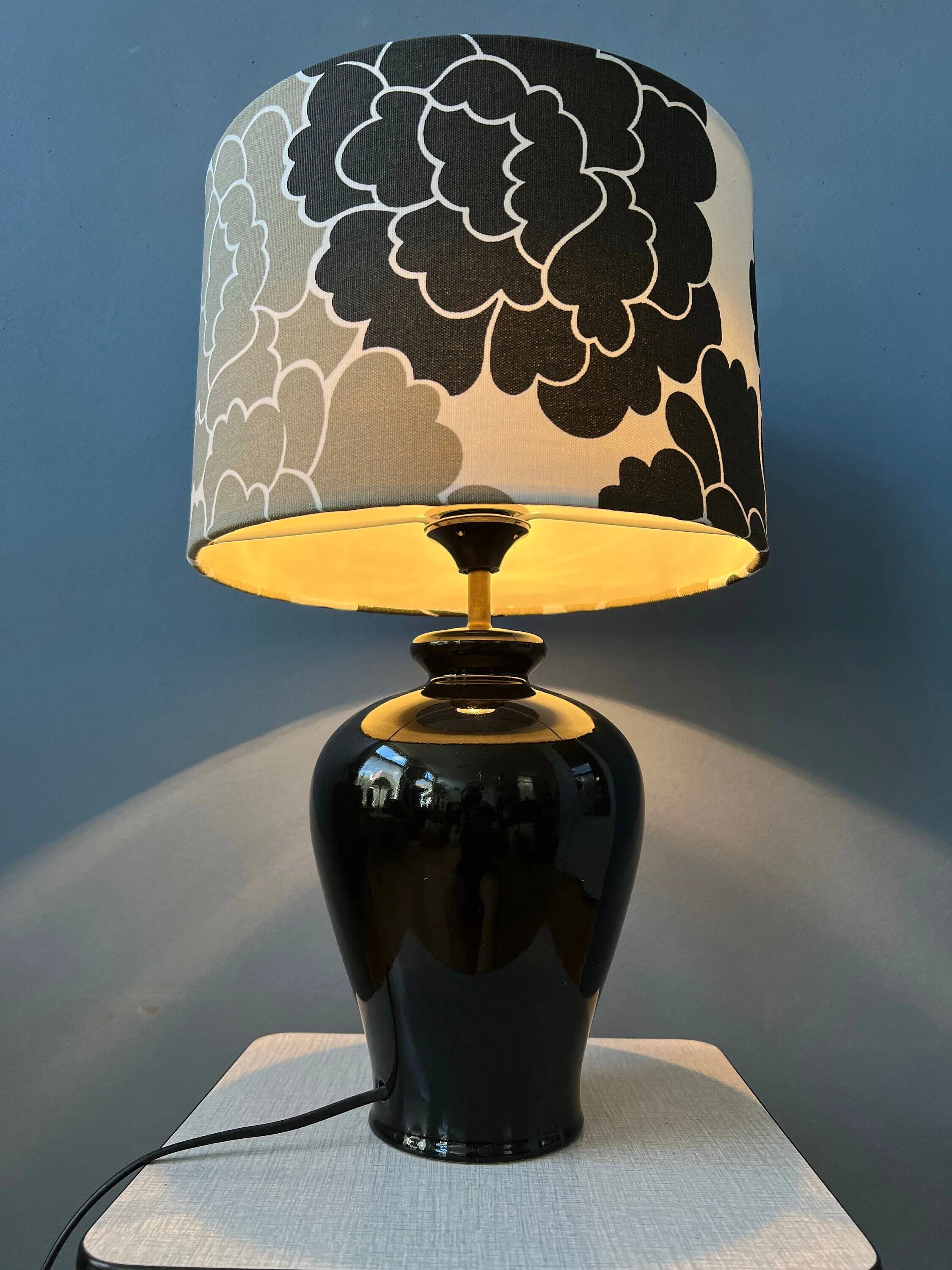 Small Space Age table lamp with a porcelain base and black and white flower shade.