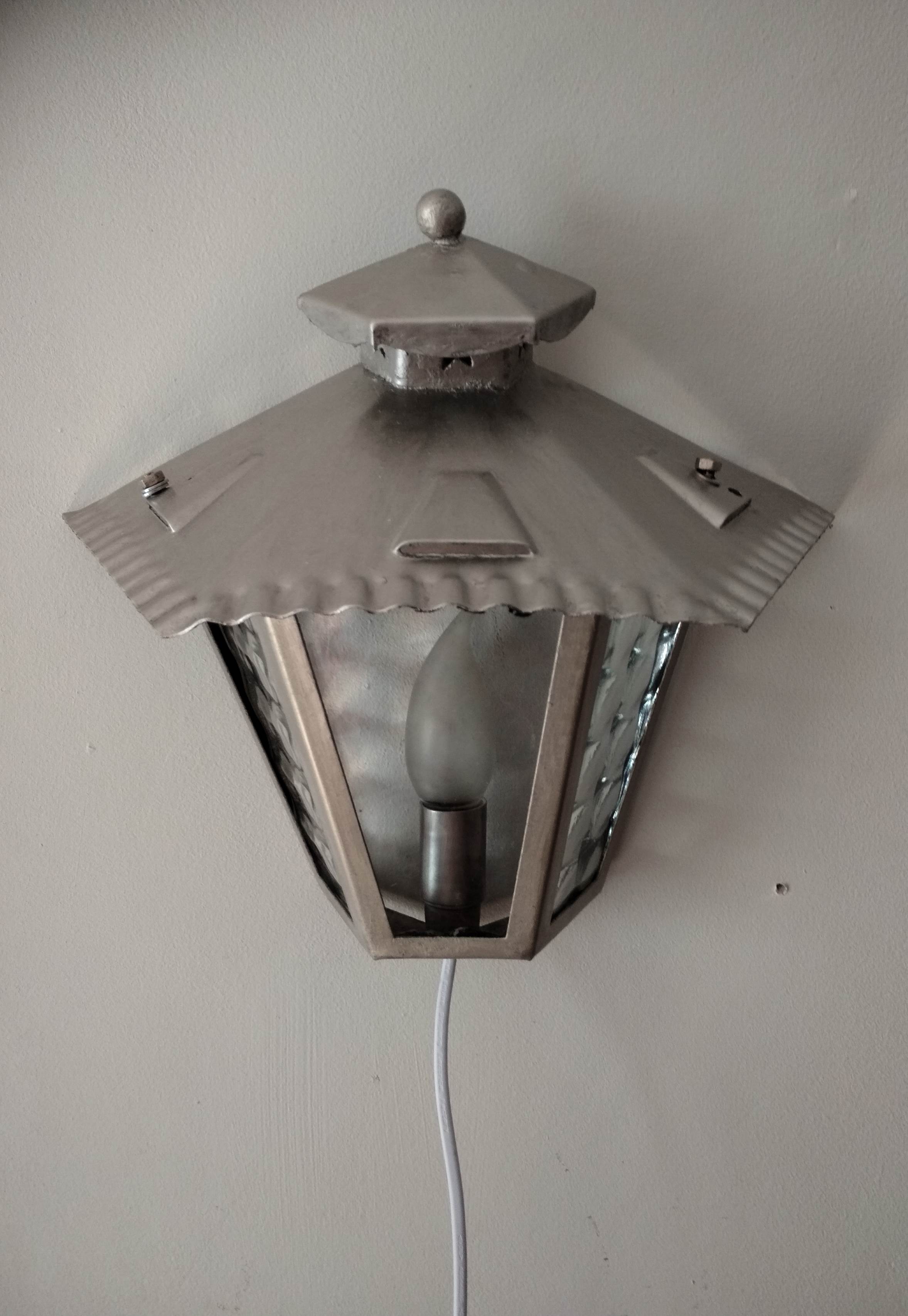 Half grey metal wall sconce and 3 windows