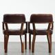 Set of two brown leather Chesterfield dining chairs in English style.