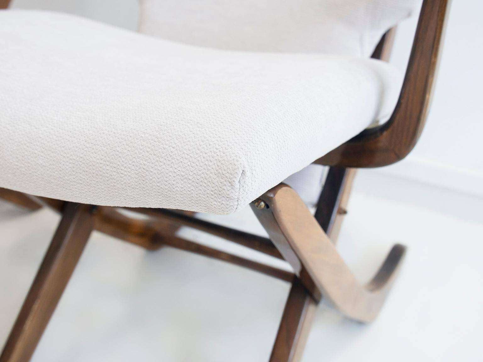 Pair of varnished wooden reclining armchairs, upholstered in lightweight fabric.