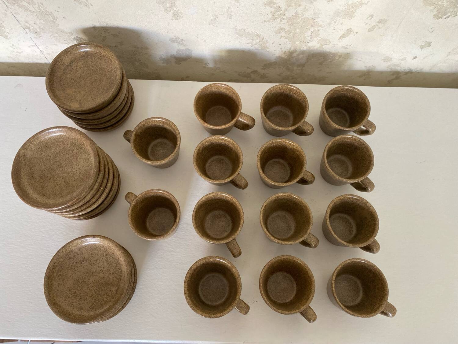 Set of stoneware coffee cups with saucers