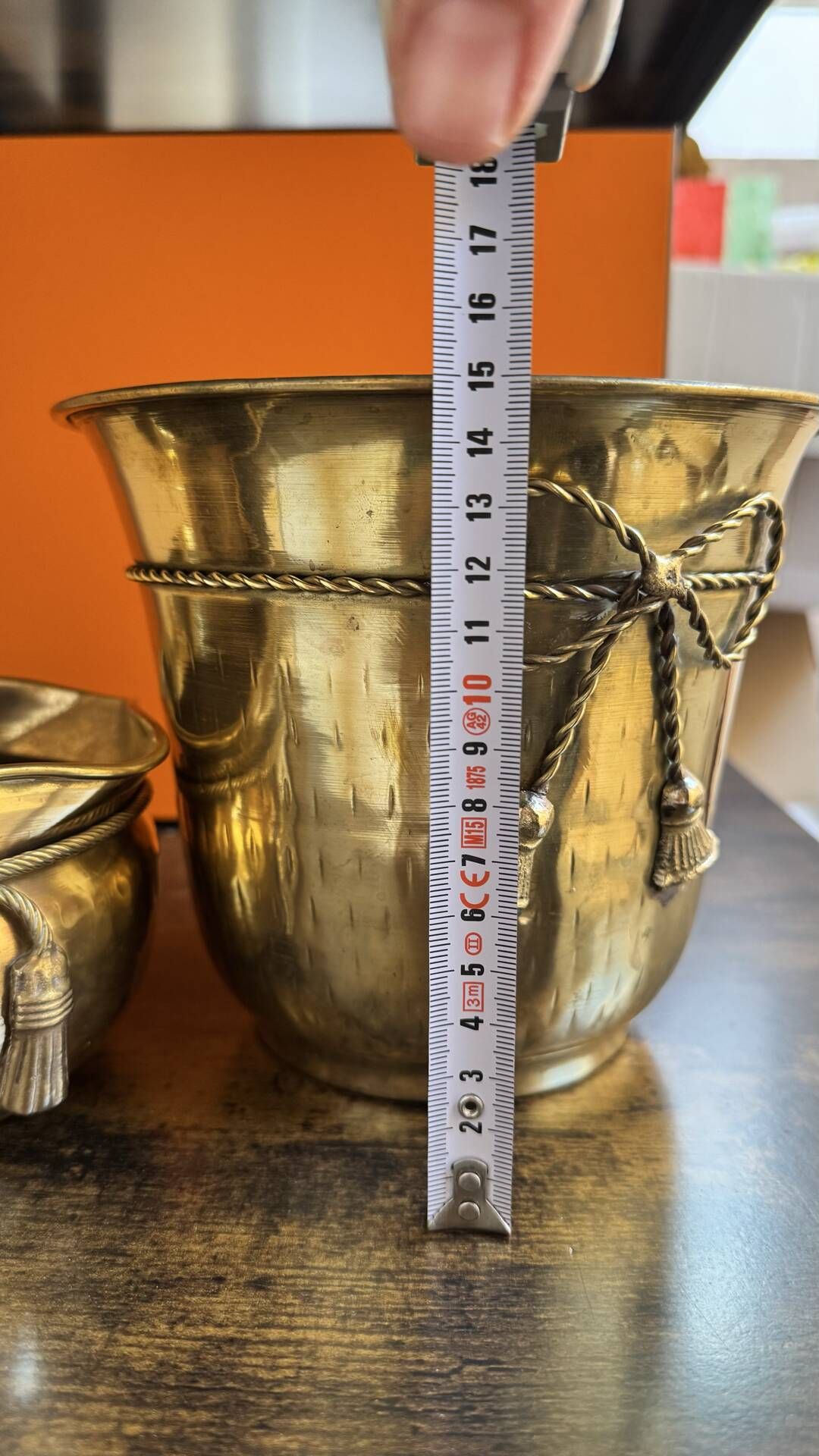 Pair of brass plant pots, decorated with cord and tassels.