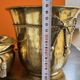 Pair of brass plant pots, decorated with cord and tassels.