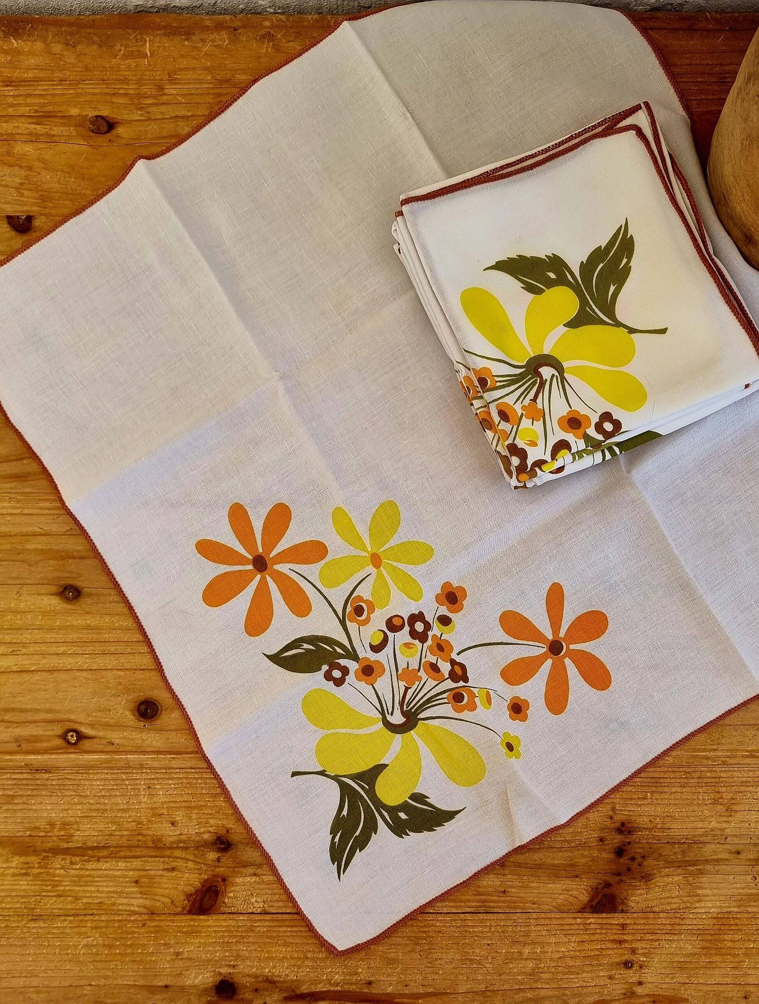 Set of 8 vintage 1970s table napkins with orange and yellow flowers.