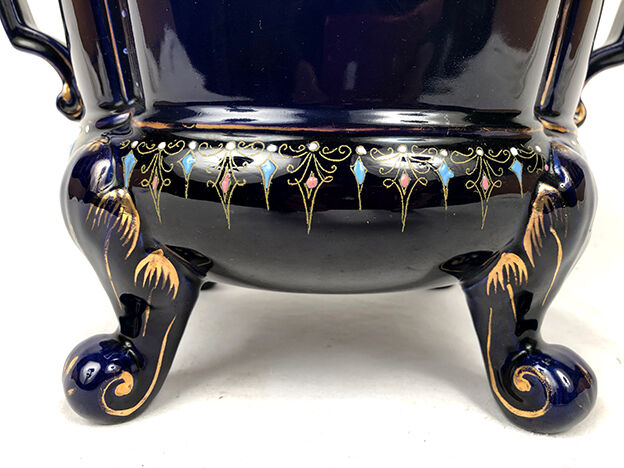 Large earthenware pot cover with enamelled decoration on a blue oven background