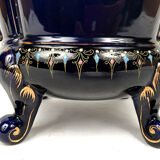 Large earthenware pot cover with enamelled decoration on a blue oven background