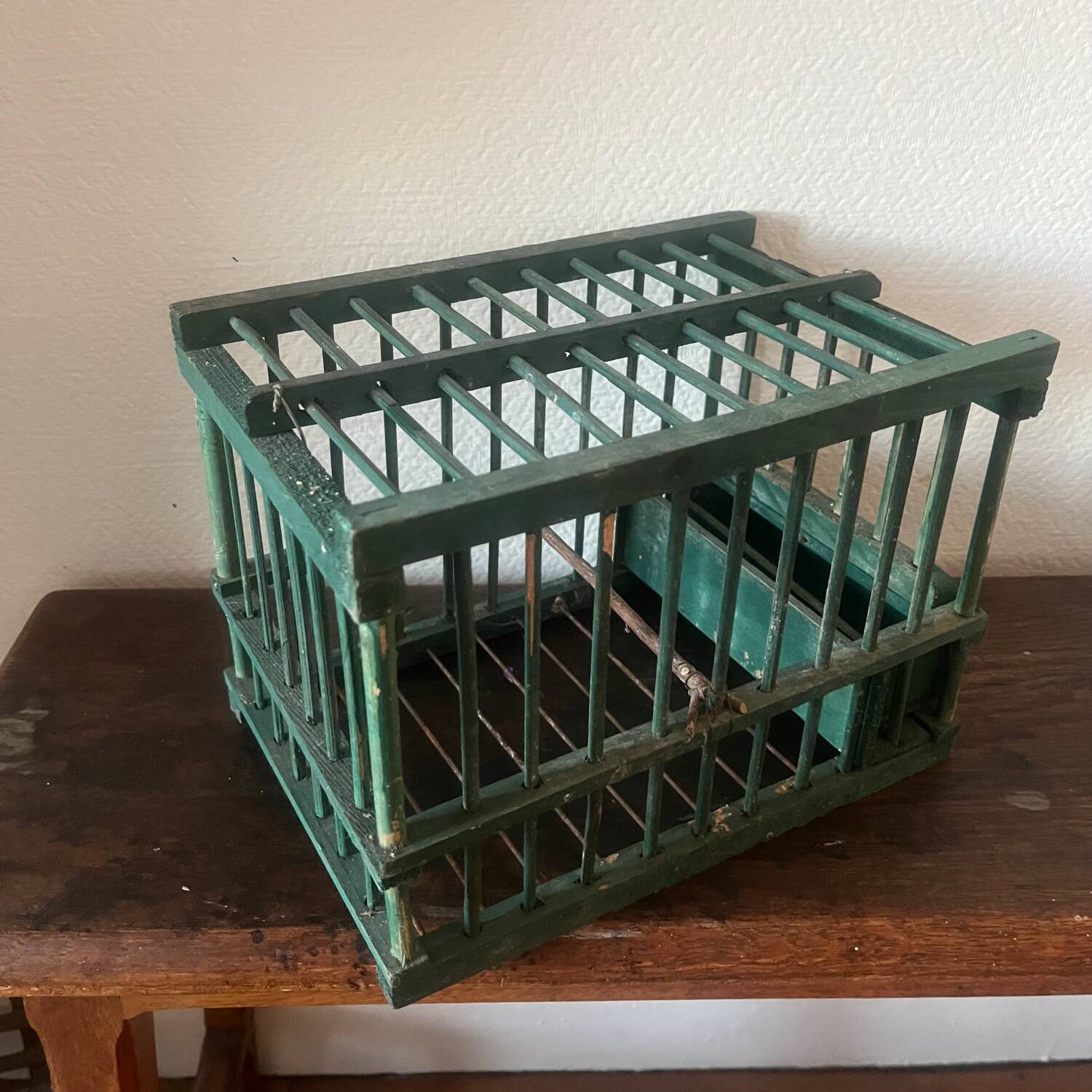 old bird cage made of wood and painted green