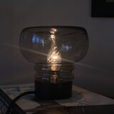 Sciolari table lamp with smoked glass globe and black plastic base.