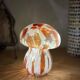 Mosaic glass mushroom lamp in orange, white, and clear.
