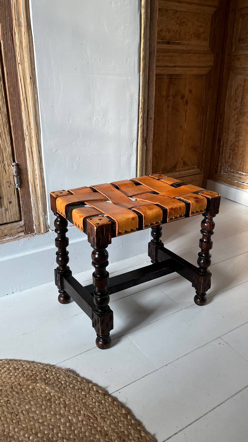 Antique turned wooden stool with woven leather.