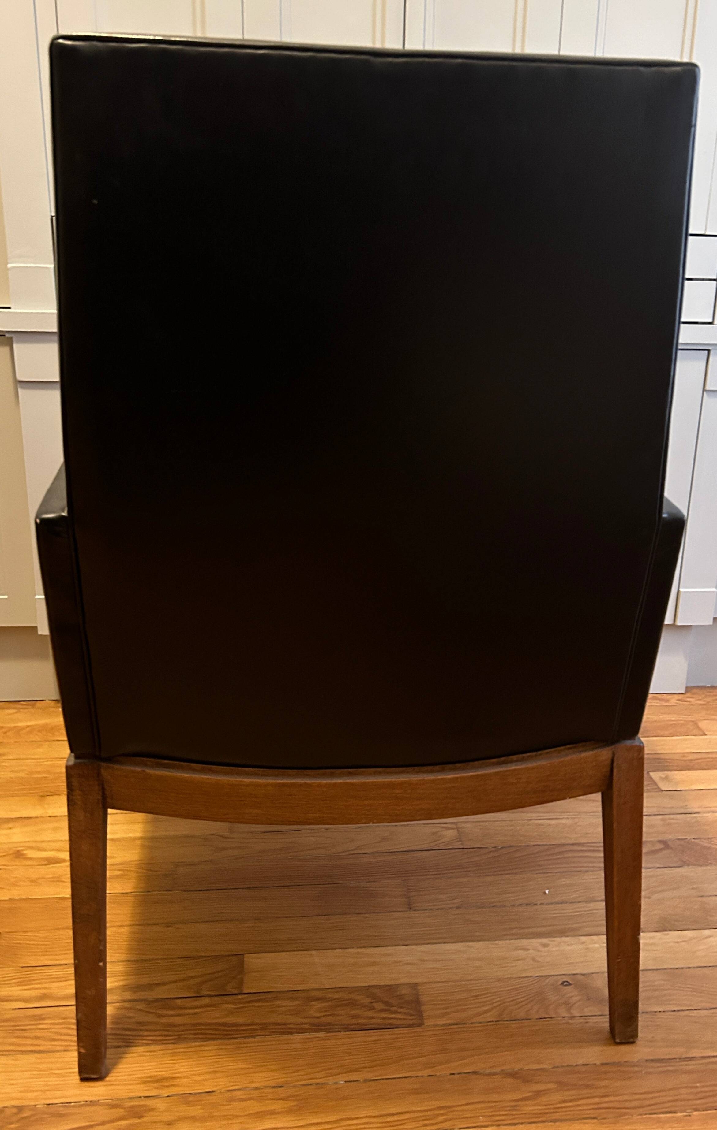 Modernist armchair in wood and black synthetic leather, circa 1960