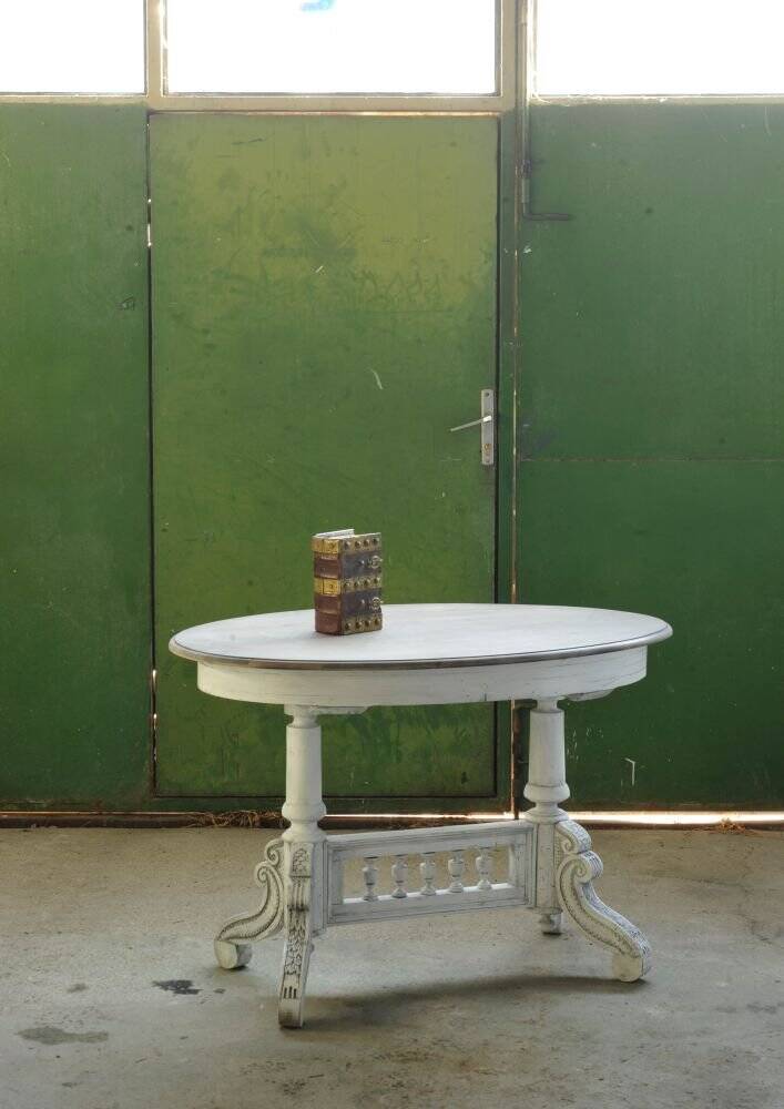 Oval coffee table in carved wood, white patina, moulded edge, from the period 1890-1919.