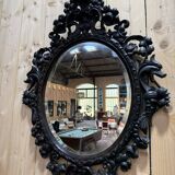 Oval mirror in carved wood with dragon heads.