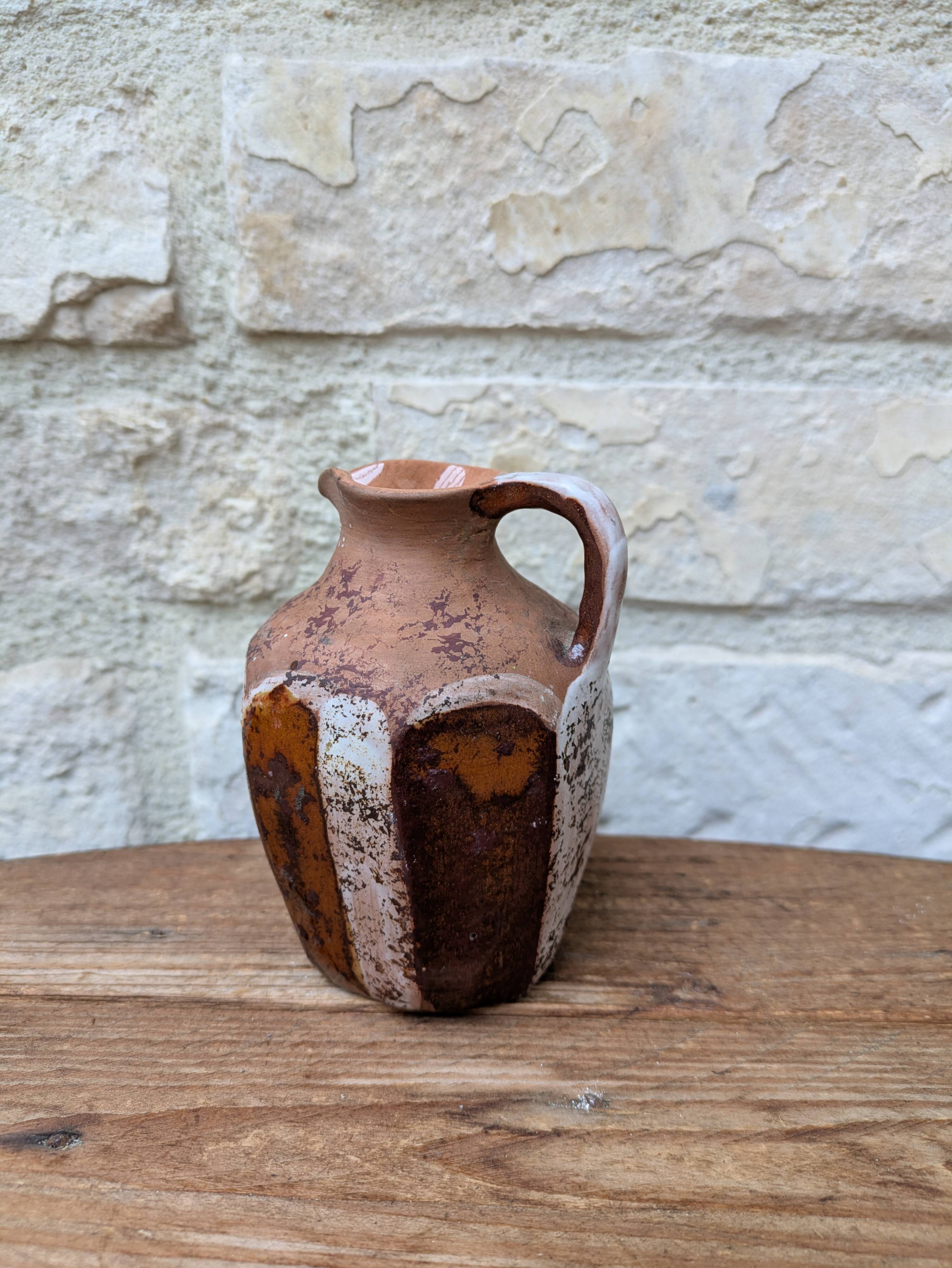 Old small pitcher in glazed terracotta