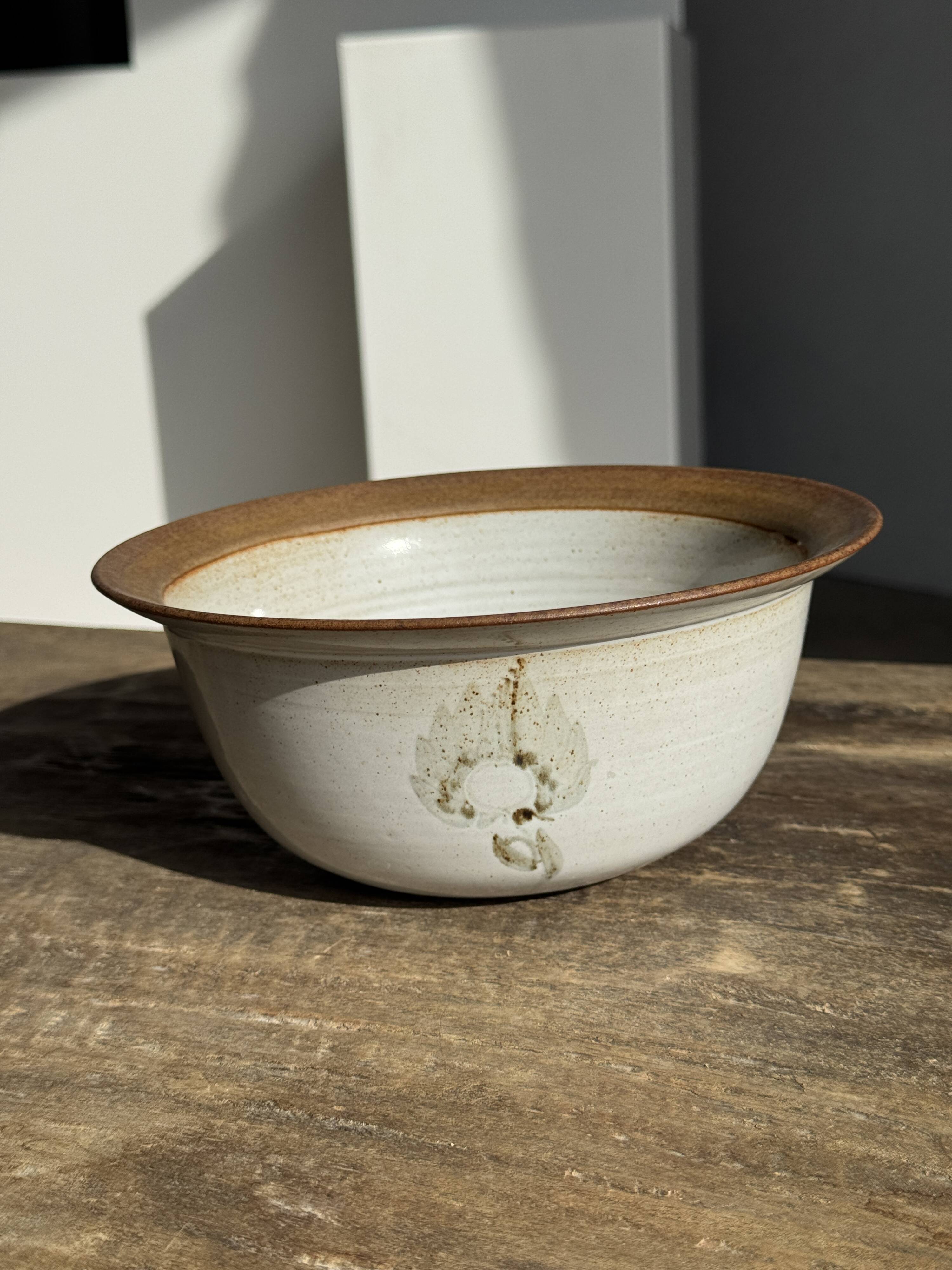 Small thick stoneware bowl with a stylised flower pattern in white on the outside, b