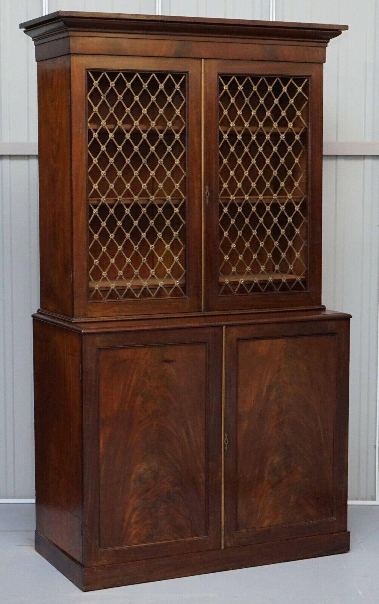 19th-century hardwood library with bronze metal doors and a chest of drawers.