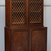 19th-century hardwood library with bronze metal doors and a chest of drawers.