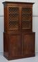 19th-century hardwood library with bronze metal doors and a chest of drawers.