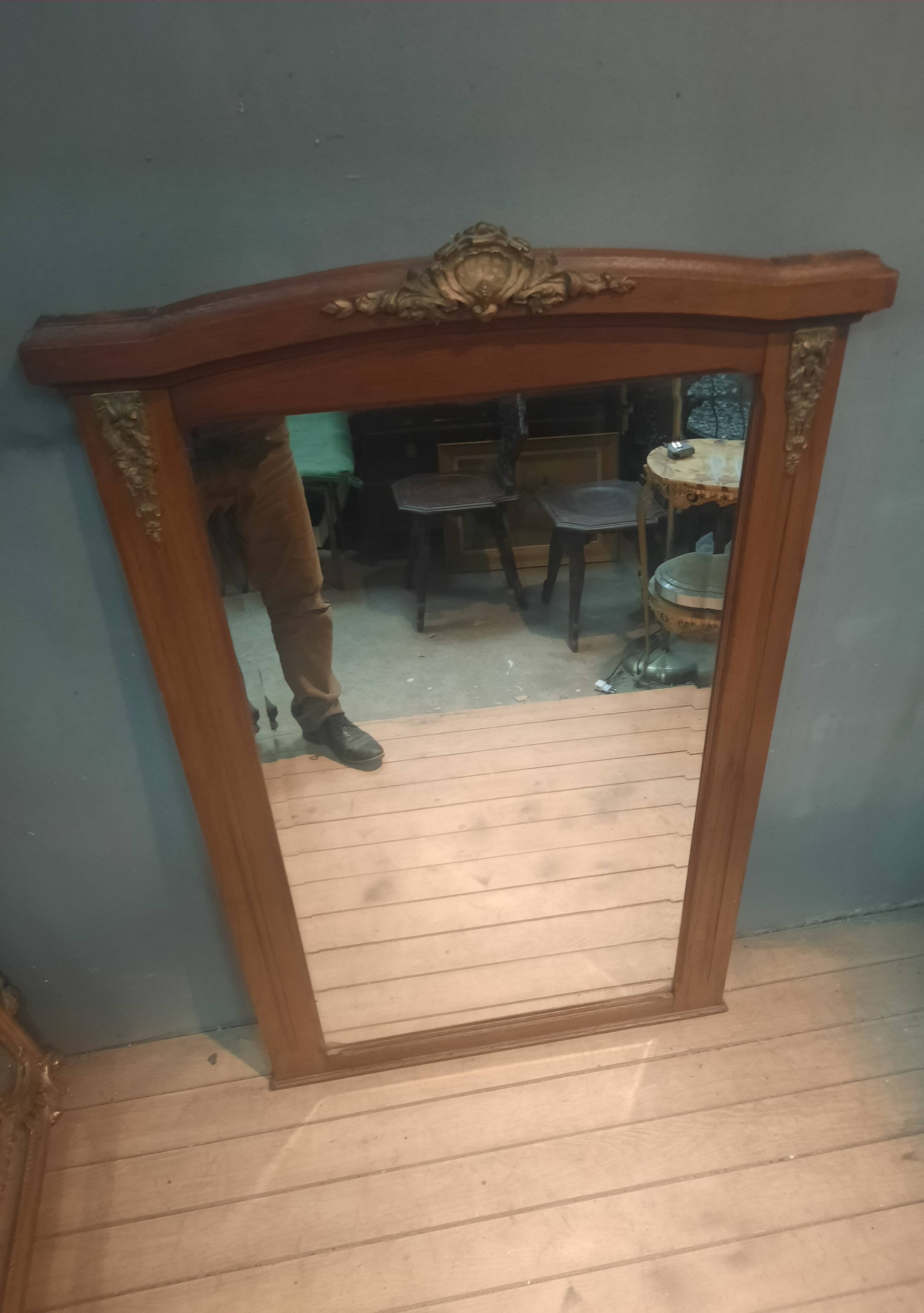 Bevelled mirror surrounded by a wooden frame.