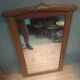 Bevelled mirror surrounded by a wooden frame.