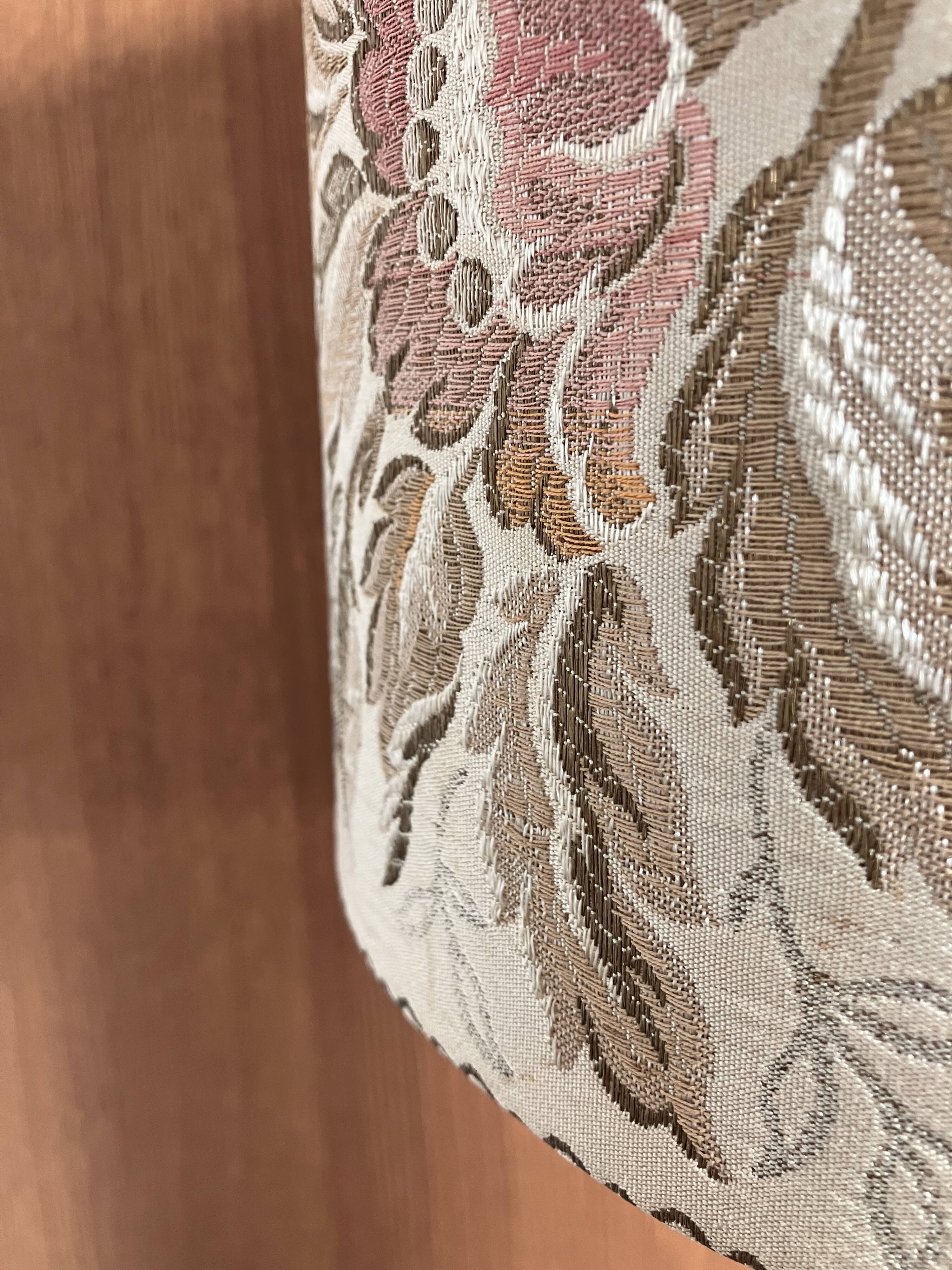 Table lamp with a solid wood printing roll and floral lampshade.
