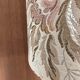 Table lamp with a solid wood printing roll and floral lampshade.