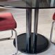 Round black smoked glass dining table + 2 terracotta chairs