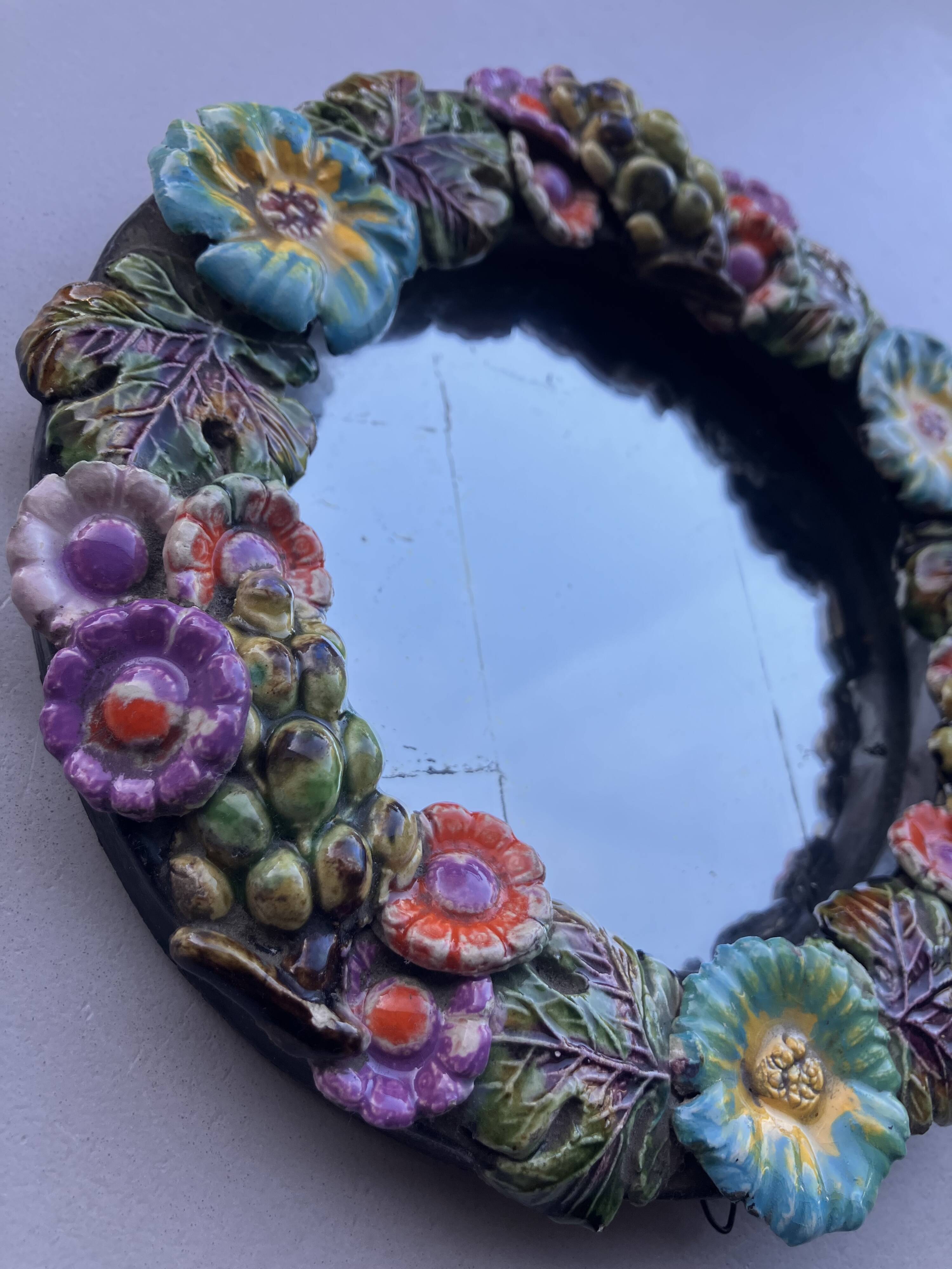 Round wall mirror in ceramic with slip-cast flowers, glazed, from the 60s/70s.