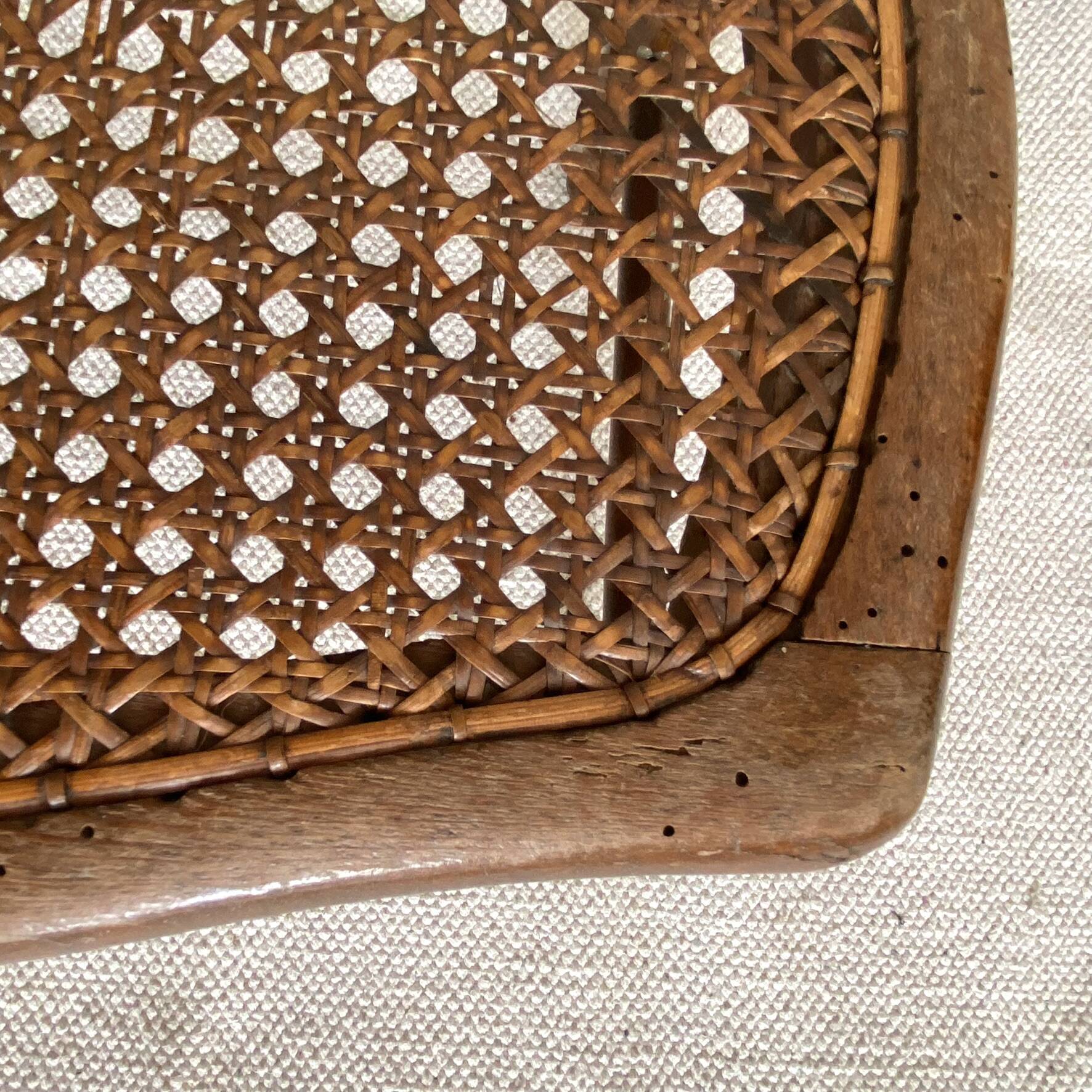 Low wooden stool with caning, footrest.