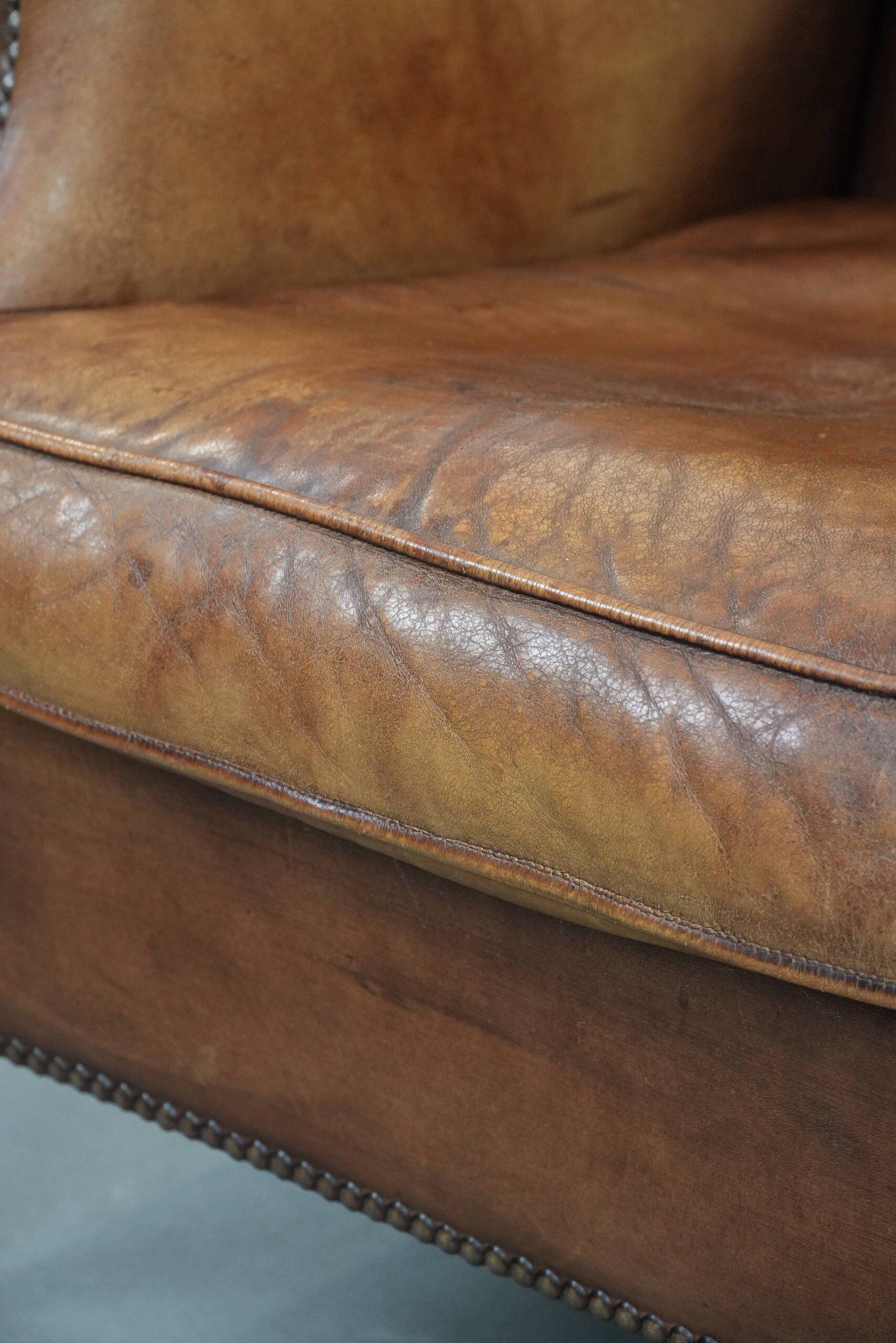 Fauteuil à oreilles en cuir de mouton charmant avec des couleurs chaudes.