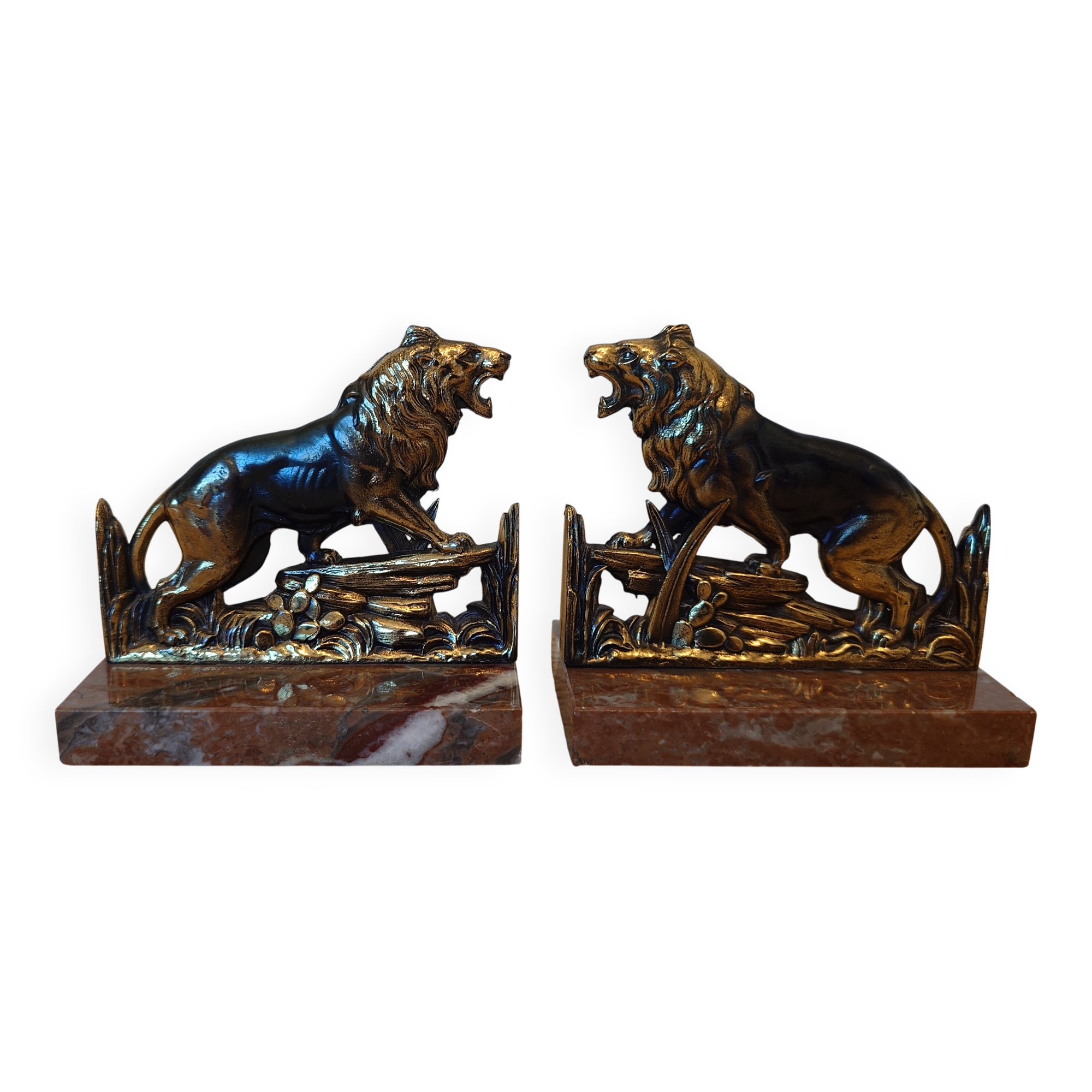 Small roaring lion bookends in patinated metal on a marble base.