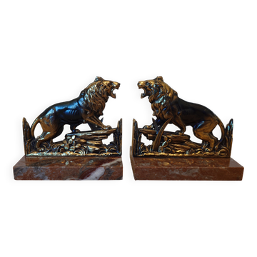 Small roaring lion bookends in patinated metal on a marble base.