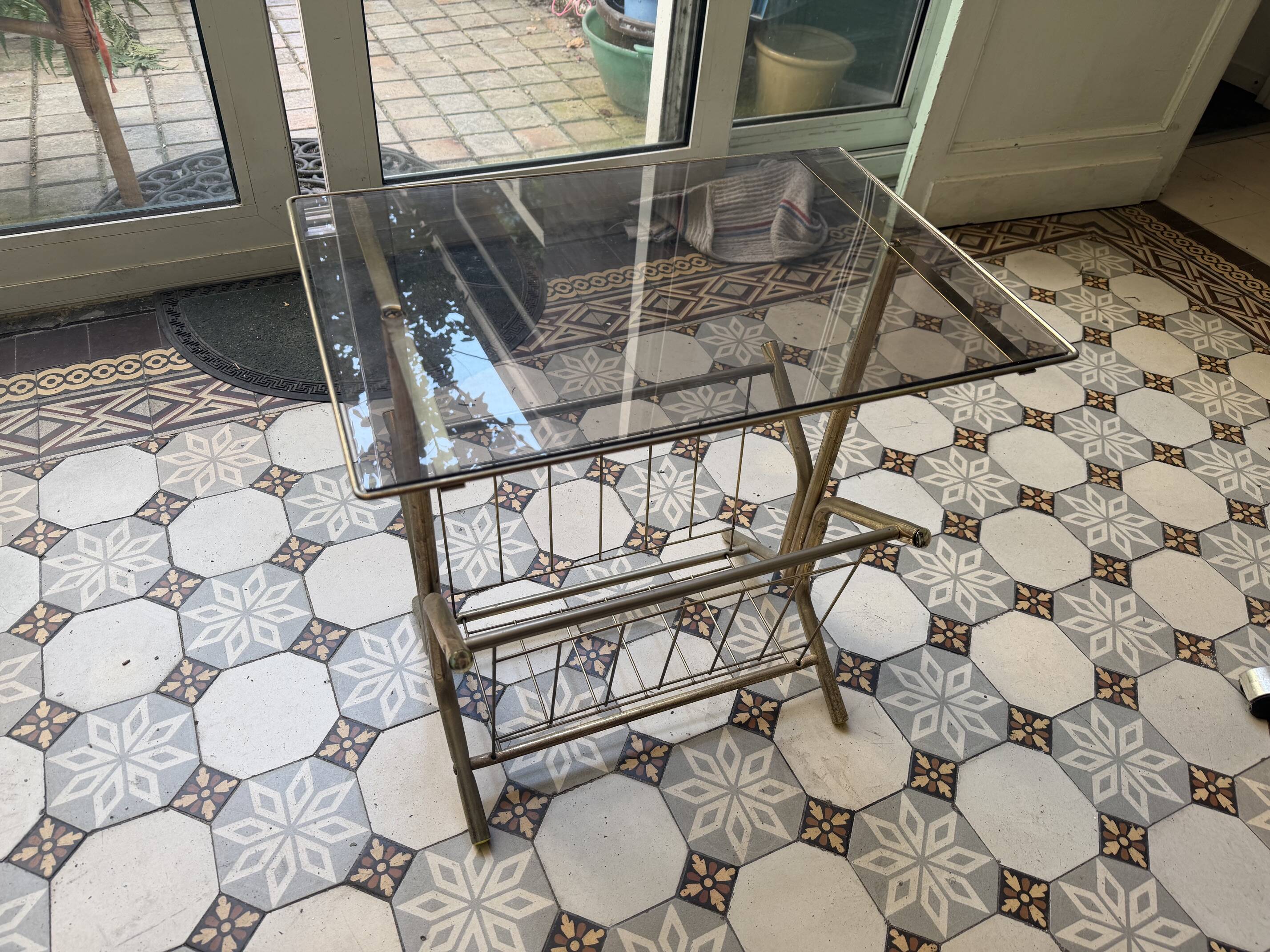 Vintage style side table with magazine holder, gold metal and glass top.