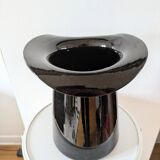 Large black glass vase topped with a 70s hat