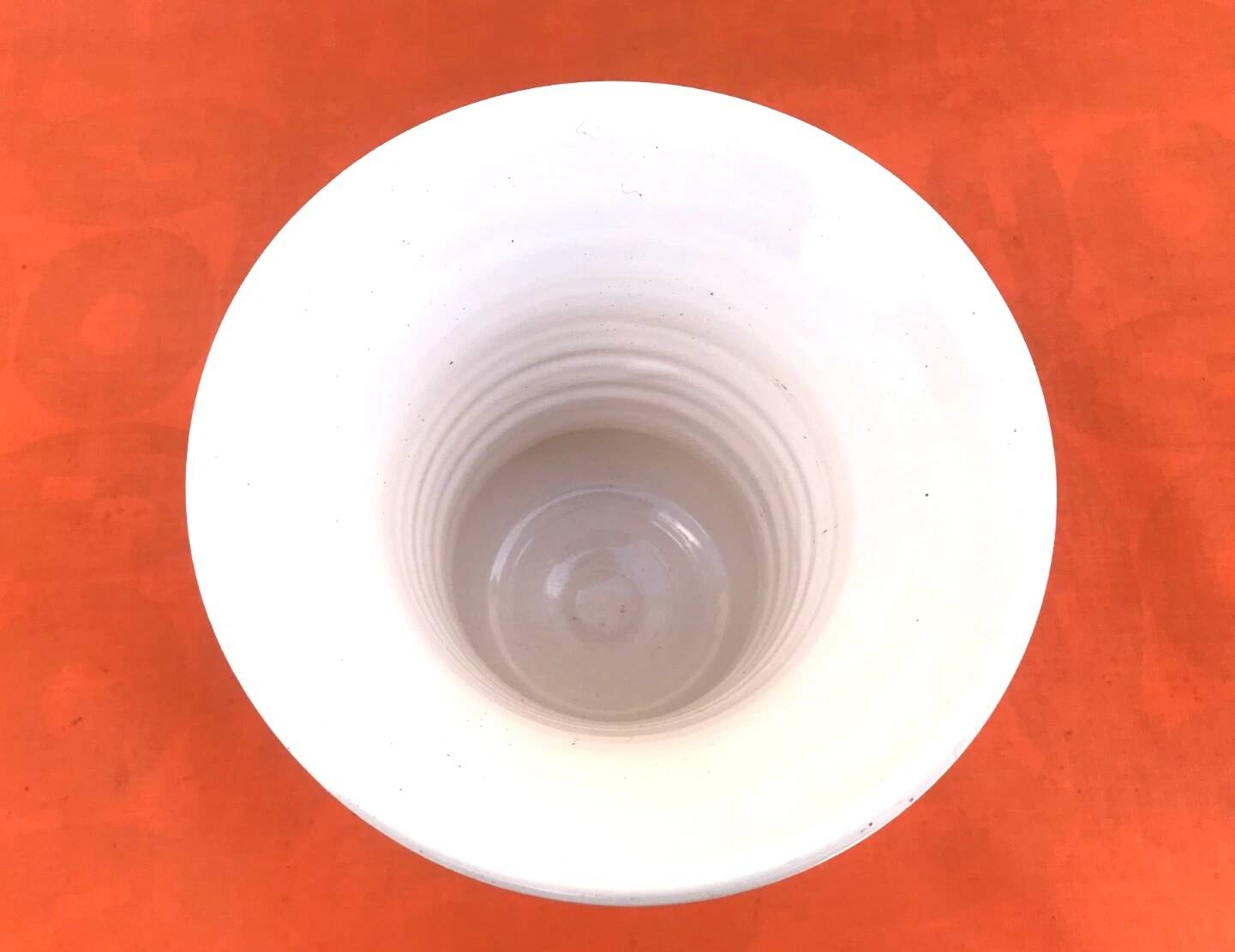 Vase on a pedestal, glazed white ceramic.