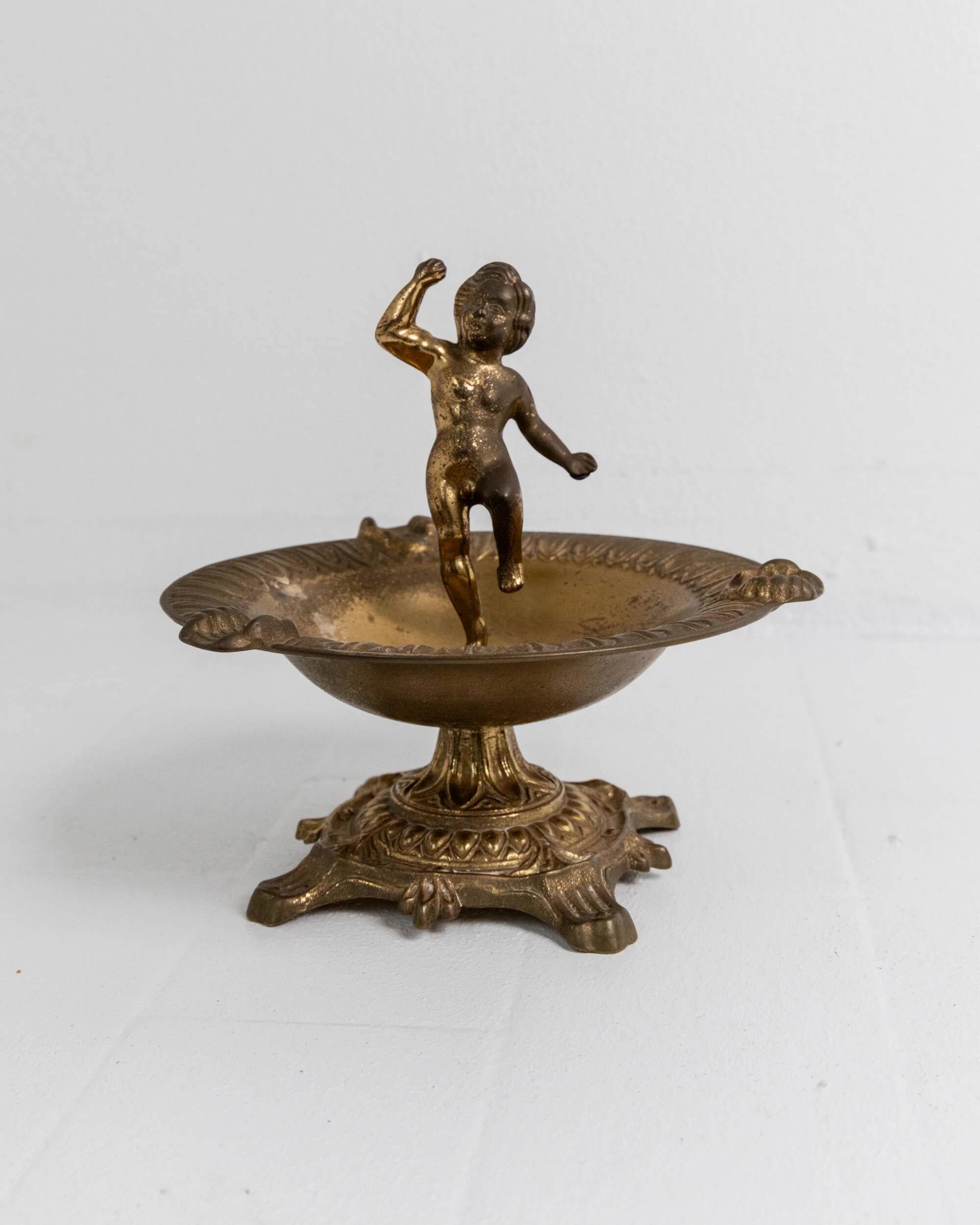 Vintage brass ashtray from the 1940s with a nude boy figurine on a footed base.