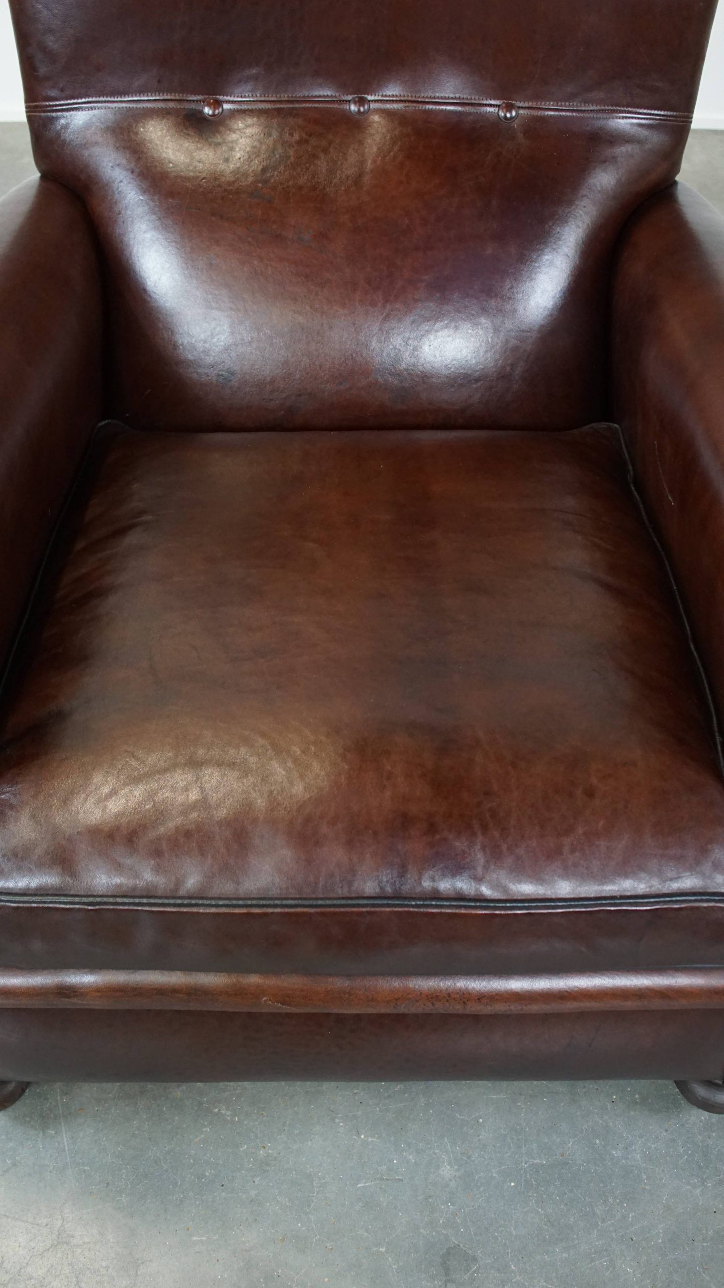 Comfortable and correct dark antique sheepskin English armchair in very good condition