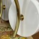 Pair of wall sconces in brass with transparent tulip glass shade.