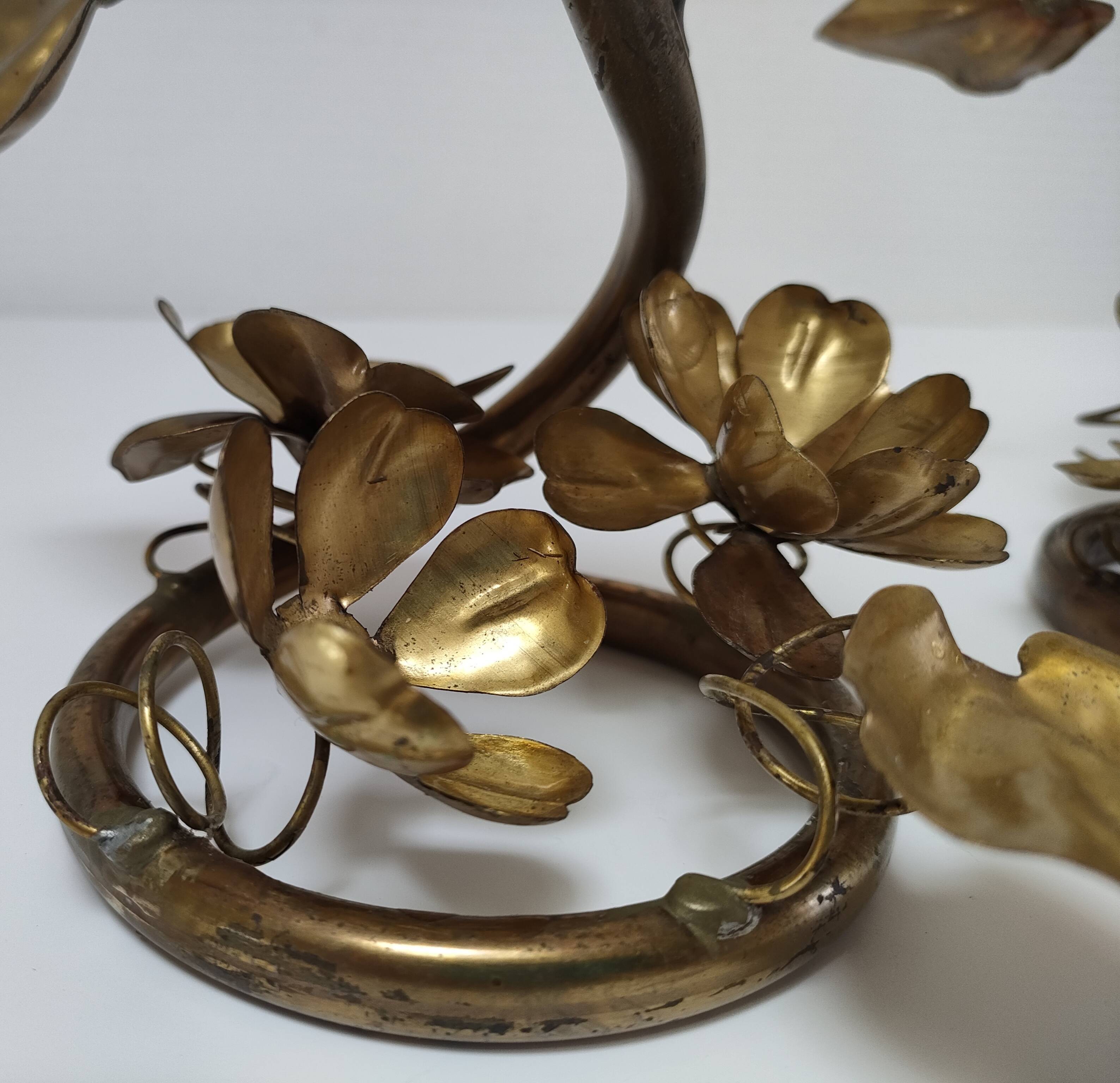 Pair of brass candle holders decorated with patinated metal flowers